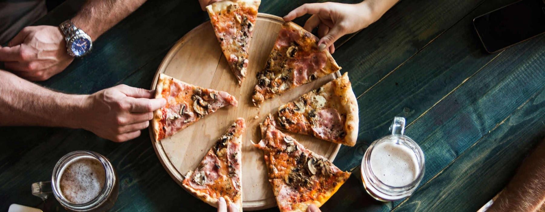 a group of people eating pizza